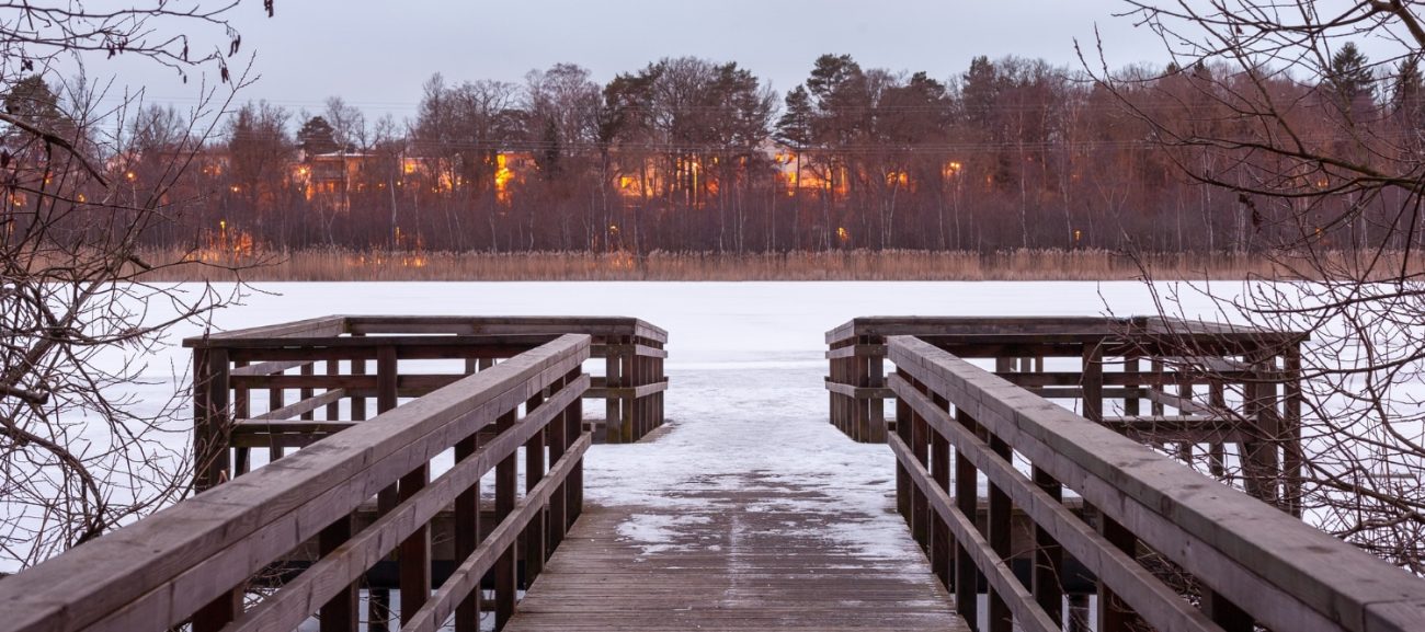 Lake of the Woods floating dock at spring ice-out with calm water and cottage Lake of the Woods floating dock at spring ice-out with calm water and cottage