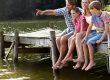 Family enjoying a beautiful Manitoba cottage waterfront with dock at sunset